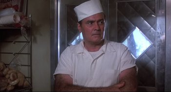 Movie still from “Psycho II” (1983), directed by Richard Franklin – A man wearing a chef's hat with his arms crossed; Close Up shot, Low angle