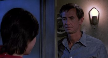 Movie still from “Psycho II” (1983), directed by Richard Franklin – A man looking into a mirror while standing next to another man; Close Up shot, Over the shoulder angle