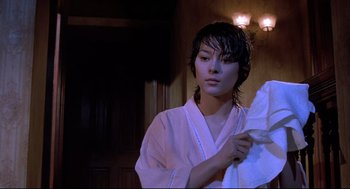 Movie still from “Psycho II” (1983), directed by Richard Franklin – A woman in a white robe holding a white towel; Medium shot, Low angle