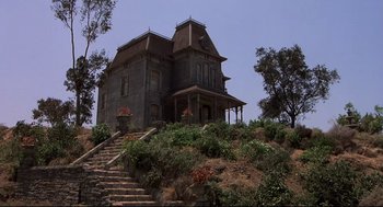 Movie still from “Psycho II” (1983), directed by Richard Franklin – A house on a hill with stairs leading up to it; Extreme Wide shot, Low angle