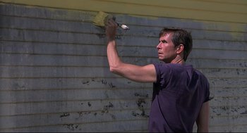 Movie still from “Psycho II” (1983), directed by Richard Franklin – A man holding a paintbrush in front of a wall; Medium shot, Low angle