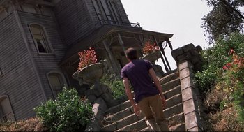 Movie still from “Psycho II” (1983), directed by Richard Franklin – A man walking down the stairs of a house; Wide shot, Low angle