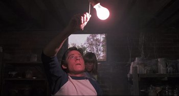 Movie still from “Psycho II” (1983), directed by Richard Franklin – A man and a woman looking up at a light bulb; Medium shot, Low angle