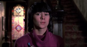 Movie still from “Psycho II” (1983), directed by Richard Franklin – A woman in a purple sweater looking to her left; Close Up shot, Low angle