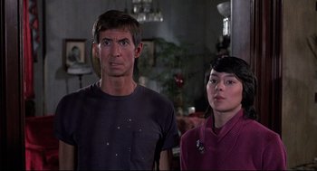 Movie still from “Psycho II” (1983), directed by Richard Franklin – A man and a woman standing next to each other in a room; Medium shot, Low angle