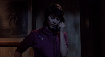 Movie still from “Psycho II” (1983), directed by Richard Franklin – A woman talking on a phone in a dark room; Close Up shot, High angle