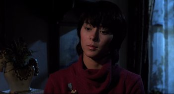 Movie still from “Psycho II” (1983), directed by Richard Franklin – A woman in a red sweater holding a knife in a dark room; Close Up shot, Low angle
