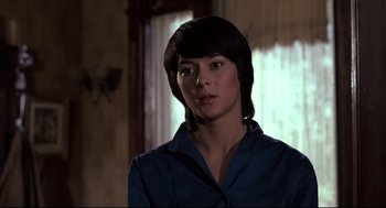 Movie still from “Psycho II” (1983), directed by Richard Franklin – A young woman with short black hair wearing a blue shirt; Close Up shot, Over the shoulder angle