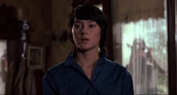 Movie still from “Psycho II” (1983), directed by Richard Franklin – A woman in a blue shirt is standing in a room; Close Up shot, Low angle