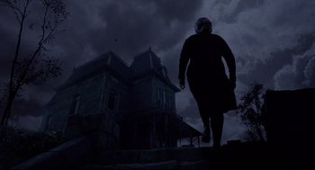 Movie still from “Psycho II” (1983), directed by Richard Franklin – A woman walking down the steps in front of a house; Wide shot, Low angle