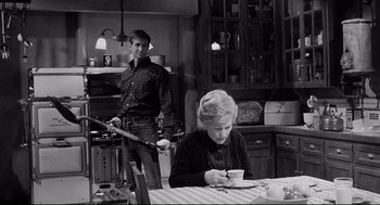 Movie still from “Psycho III” (1986), directed by Anthony Perkins – An older woman and a younger man in a kitchen; Medium shot, Over the shoulder angle