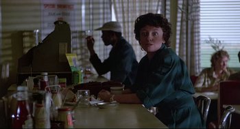 Movie still from “Psycho III” (1986), directed by Anthony Perkins – A woman sitting at a table in front of a man; Medium shot, Over the shoulder angle