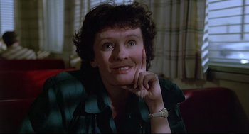 Movie still from “Psycho III” (1986), directed by Anthony Perkins – A person sitting on a couch; Close Up shot, Low angle