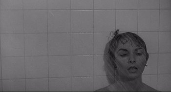 Movie still from “Psycho III” (1986), directed by Anthony Perkins – A black - and - white photo of a woman taking a shower; Close Up shot, Over the shoulder angle