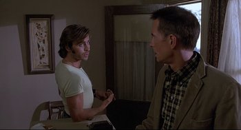 Movie still from “Psycho III” (1986), directed by Anthony Perkins – Two men are talking in a room; Medium shot, Over the shoulder angle