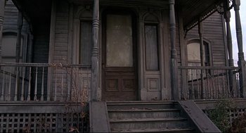 Movie still from “Psycho III” (1986), directed by Anthony Perkins – An old wooden door and steps leading up to a porch; Wide shot, Low angle