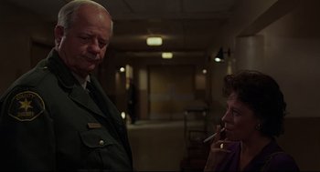 Movie still from “Psycho III” (1986), directed by Anthony Perkins – An older man and a younger woman in a hallway; Medium shot, Over the shoulder angle