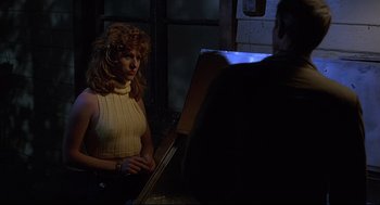 Movie still from “Psycho III” (1986), directed by Anthony Perkins – A woman standing in front of a painting; Medium shot, Over the shoulder angle