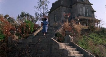 Movie still from “Psycho III” (1986), directed by Anthony Perkins – A woman walking down a set of stairs; Wide shot, Low angle