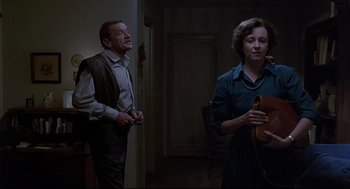 Movie still from “Psycho III” (1986), directed by Anthony Perkins – A man and a woman standing next to each other in a room; Medium shot, Low angle