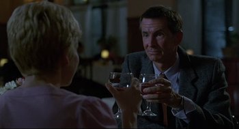 Movie still from “Psycho III” (1986), directed by Anthony Perkins – A man and a woman sitting at a table with wine glasses; Close Up shot, Over the shoulder angle