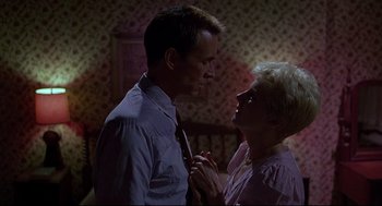 Movie still from “Psycho III” (1986), directed by Anthony Perkins – A man and a woman standing next to each other; Medium shot, Low angle