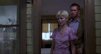 Movie still from “Psycho III” (1986), directed by Anthony Perkins – A man and a woman standing next to each other in a room; Medium shot, Low angle