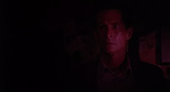 Movie still from “Psycho III” (1986), directed by Anthony Perkins – A man in a dark room with his eyes wide open; Close Up shot, Low angle