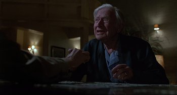 Movie still from “Psycho III” (1986), directed by Anthony Perkins – An older man sitting at a table with a woman; Close Up shot, Over the shoulder angle