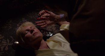 Movie still from “Psycho III” (1986), directed by Anthony Perkins – An older woman laying on the ground with her hands raised; Close Up shot, High angle