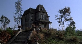 Movie still from “Psycho III” (1986), directed by Anthony Perkins – An old house with a clock on the top of it; Extreme Wide shot, Low angle