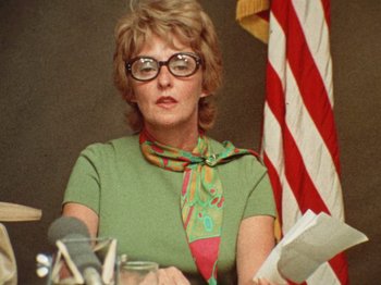 An older woman wearing glasses and a green shirt