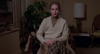 Movie still from “Puzzle of a Downfall Child” (1970), directed by Jerry Schatzberg – A woman sitting in a chair holding a cigar; Medium shot, Low angle