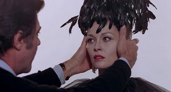Movie still from “Puzzle of a Downfall Child” (1970), directed by Jerry Schatzberg – A man putting a feather on the head of a woman; Close Up shot, Over the shoulder angle