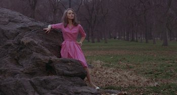 Movie still from “Puzzle of a Downfall Child” (1970), directed by Jerry Schatzberg – A woman in a pink dress leaning on a rock; Medium shot, High angle