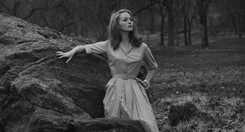 Movie still from “Puzzle of a Downfall Child” (1970), directed by Jerry Schatzberg – A woman standing next to a rock in a field; Medium shot, Low angle