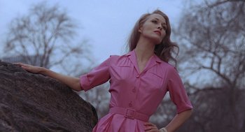 Movie still from “Puzzle of a Downfall Child” (1970), directed by Jerry Schatzberg – A woman in a pink dress standing next to a tree; Medium shot, Low angle
