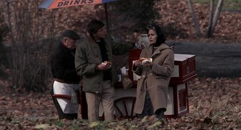 Movie still from “Puzzle of a Downfall Child” (1970), directed by Jerry Schatzberg – A man and a woman standing in front of a food cart; Medium shot, High angle