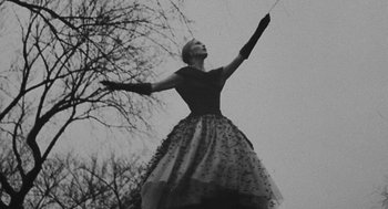 Movie still from “Puzzle of a Downfall Child” (1970), directed by Jerry Schatzberg – A woman in a black dress is holding a stick; Medium shot, Low angle