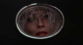 Movie still from “Puzzle of a Downfall Child” (1970), directed by Jerry Schatzberg – A woman's face is reflected in a round mirror; Close Up shot, Low angle