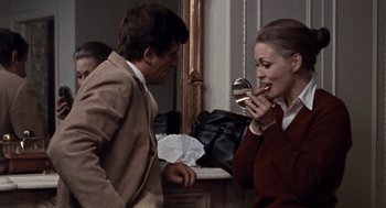 Movie still from “Puzzle of a Downfall Child” (1970), directed by Jerry Schatzberg – A man and a woman standing next to each other in front of a mirror; Medium shot, Over the shoulder angle