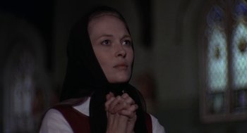Movie still from “Puzzle of a Downfall Child” (1970), directed by Jerry Schatzberg – A woman with a black headscarf is holding her hands in prayer; Close Up shot, Low angle
