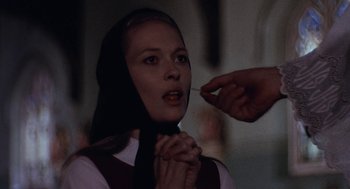Movie still from “Puzzle of a Downfall Child” (1970), directed by Jerry Schatzberg – A woman with a black headscarf is getting her nose pierced; Close Up shot, Low angle