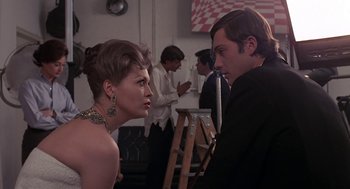 Movie still from “Puzzle of a Downfall Child” (1970), directed by Jerry Schatzberg – A man and a woman in formal wear in a room; Medium shot, Over the shoulder angle