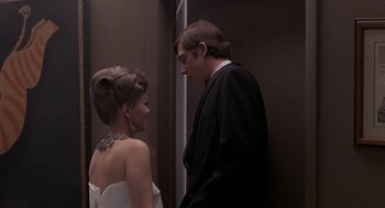 Movie still from “Puzzle of a Downfall Child” (1970), directed by Jerry Schatzberg – A man and a woman standing next to each other; Medium shot, Low angle