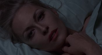 Movie still from “Puzzle of a Downfall Child” (1970), directed by Jerry Schatzberg – A woman laying in a bed with her hand on her chin; Close Up shot, Overhead angle