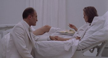 Movie still from “Puzzle of a Downfall Child” (1970), directed by Jerry Schatzberg – A man and a woman sitting on a bed in a hospital room; Medium shot, Overhead angle