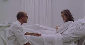 Movie still from “Puzzle of a Downfall Child” (1970), directed by Jerry Schatzberg – A man and a woman sitting on a bed; Medium shot, High angle