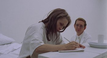 Movie still from “Puzzle of a Downfall Child” (1970), directed by Jerry Schatzberg – A woman writing on a piece of paper next to a man; Medium shot, Low angle