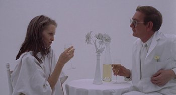 Movie still from “Puzzle of a Downfall Child” (1970), directed by Jerry Schatzberg – A man and a woman sitting at a table drinking wine; Medium shot, High angle